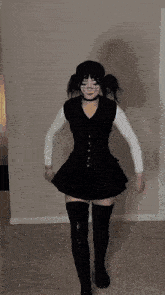 a woman is wearing a black dress and black boots