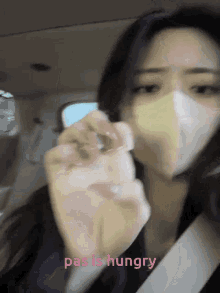 a woman wearing a mask says pas is hungry in pink