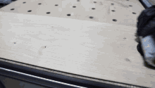 a person is cutting a piece of wood with a circular saw