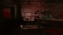 a blurry picture of a dark room with a red light coming out of a window .
