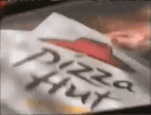 a pizza hut box with a red arrow on the top