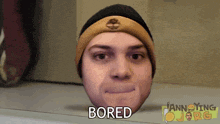 a man wearing a beanie has the word bored written on his head