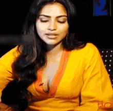 a woman in a yellow shirt is sitting in front of a microphone .