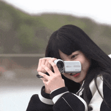 a girl is taking a picture with a camera that says panasonic on it