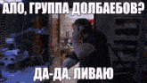 a man talking on a cell phone in a dark room with russian writing