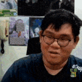 a man wearing glasses is wearing a shirt that says sinji