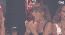 two women are sitting in a stadium with the nfl logo visible