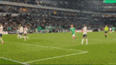 a soccer game is being played in a stadium with a few players in white