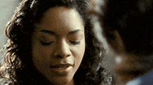 a woman with curly hair is looking down at something