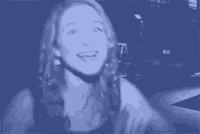 a woman is making a funny face and waving her hands in the air .