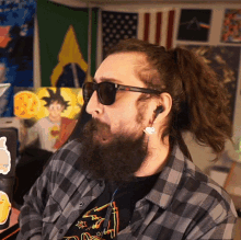 a bearded man wearing sunglasses and a plaid shirt