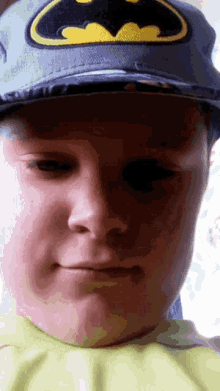 a boy wearing a batman hat makes a funny face