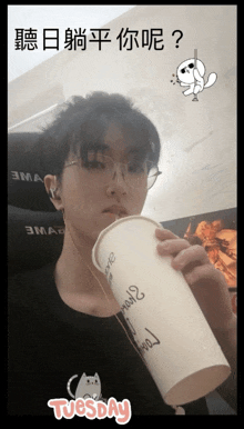 a person is drinking from a cup that says tuesday on it