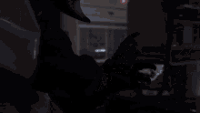 a person wearing a black leather jacket and a white shirt has a bottle of toothpaste in their hand