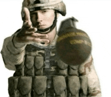a man in a military uniform is holding a bomb and pointing at the camera