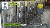 a man in a yellow shirt stands in front of a row of refrigerators