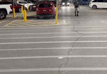 a red car with a california license plate is parked in a lot