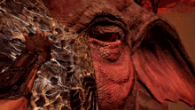 a close up of a dragon 's eye with a person holding a sword behind it