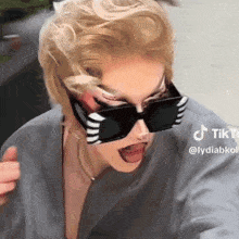 a woman wearing sunglasses is giving a thumbs up with a tiktok watermark
