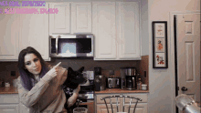 a woman with purple hair holds a black dog in front of a microwave and says her goal is 2070/2500
