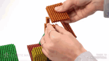 a person is playing with magnetic beads that are made in animotica