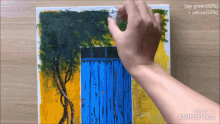 a person is painting a blue door on a yellow and green background