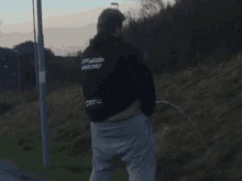 a man wearing a black jacket that says crew on the back