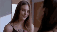 two women are standing next to each other and looking at each other in a room .