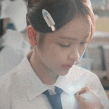 a girl with a hair clip in her hair is looking down