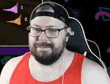 a man wearing a red tank top and a black hat that says " evolve "