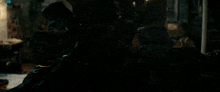 a man is standing in a dark room with a light coming out of his hand .