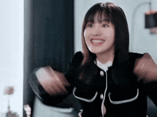 a young woman wearing headphones is smiling and holding her arms in the air .