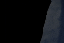a blurred image of a person holding a cross in a dark room