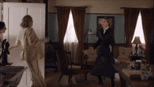 a woman in a black dress is dancing in a living room with brown curtains