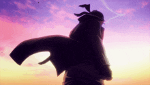 a silhouette of a man standing in front of a purple sky