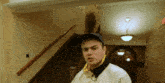 a man wearing a blue hat and a white jacket is standing in a hallway