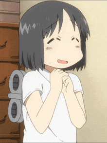 a girl in a white shirt is praying with a toy on her back