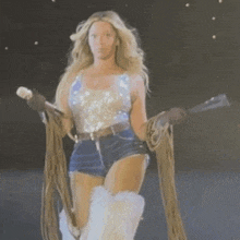 a woman in shorts and boots is holding a microphone in her hand