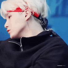 a close up of a person wearing a bandana around their head and earrings .