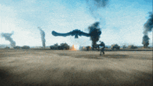 a blurred image of a battlefield with smoke coming out of the sky