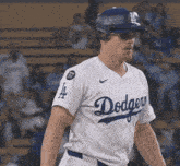 a man wearing a dodgers jersey and a helmet