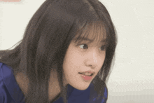 a close up of a woman 's face with a blue shirt
