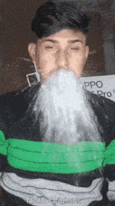a man in a green and black striped shirt is spitting water from his mouth