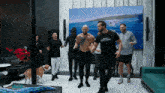 a group of men are dancing in a living room and one of them is wearing a shirt that says " world without corruption "
