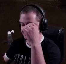 a man wearing headphones is crying while sitting in a chair .