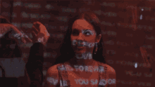 a woman 's face is projected on a wall with the words " said forever " written on it