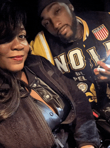 a man and a woman are posing for a picture and the man is wearing a jersey that says no 1