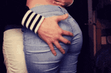 a man is touching a woman 's butt in jeans