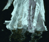 a woman in a long white dress is standing in the water