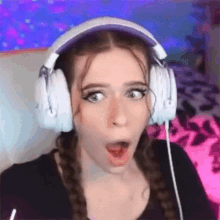a woman is wearing headphones and making a funny face .